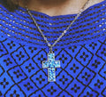 Sparkling blue crystal cross necklace featuring a silver chain and detailed pendant, elegant jewelry accessory.