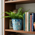 Turquoise mother of pearl flower pot with floral design, showcasing glossy, iridescent surface and decorative nature.