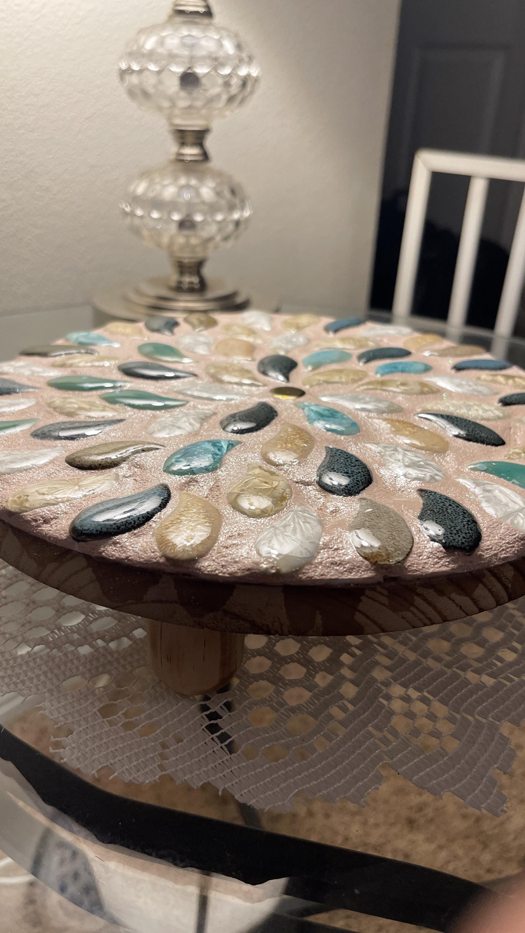 Handcrafted botanical petal mosaic plant stand with colorful floral design, made for supporting potted plants.