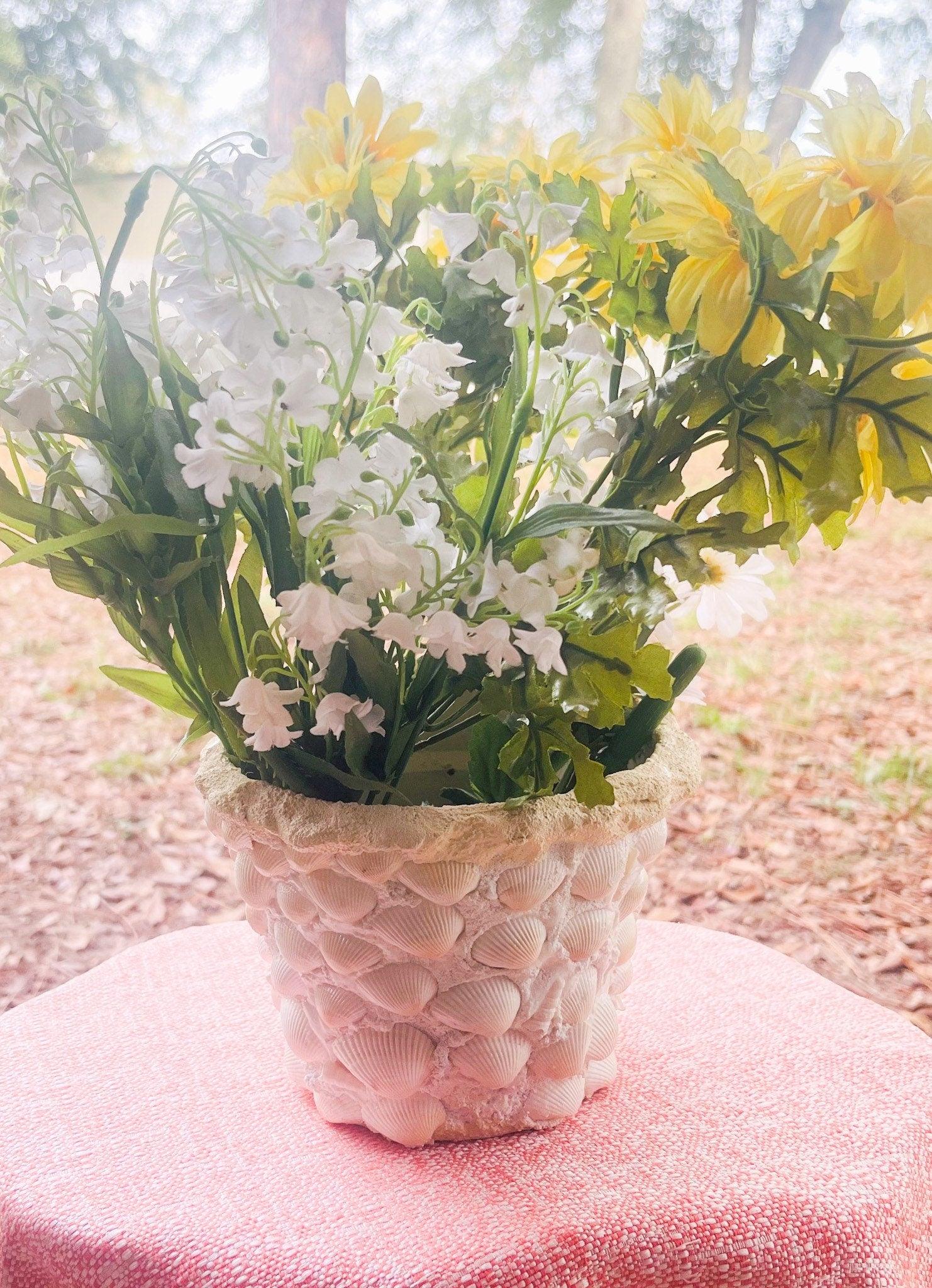 Handcrafted seashell mosaic plant pot with colorful shell patterns, perfect for adding coastal charm to indoor or outdoor plants.