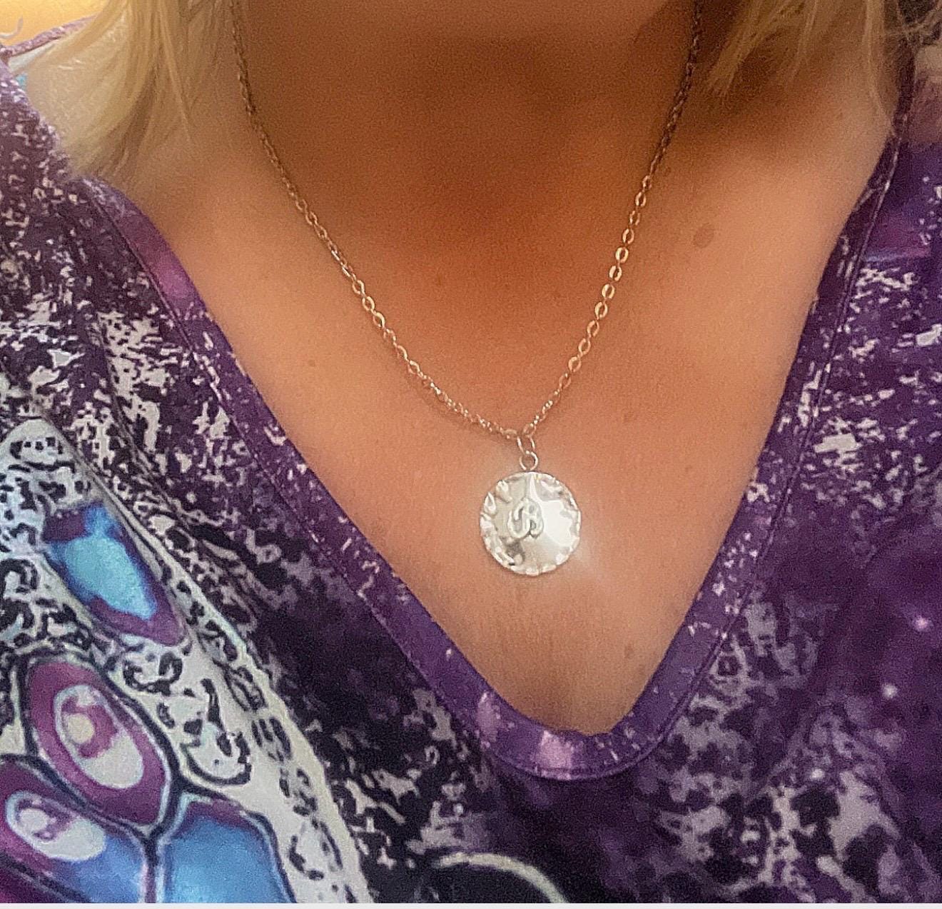 Vintage initial charm necklace with silver chain and personalized letter pendant, showcasing elegant jewelry design.