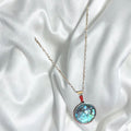 Teal blue crushed glass and silver round pendant necklace with a sleek, modern design, featuring a polished silver chain and vibrant pendant.