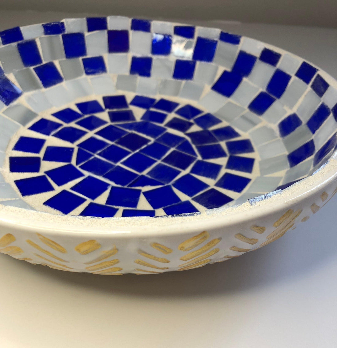 Blue and white stained glass bowl with intricate design, perfect for decorative or functional use.