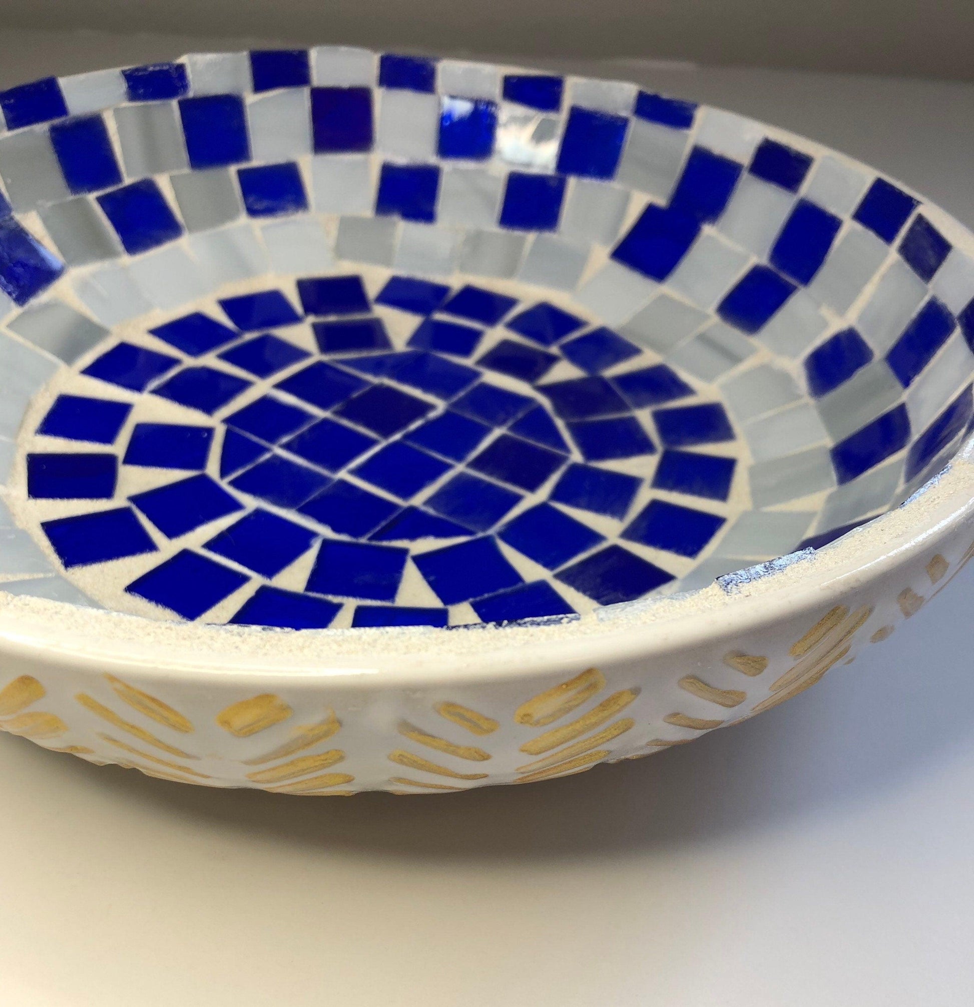 Blue and white stained glass bowl with intricate design, perfect for decorative or functional use.