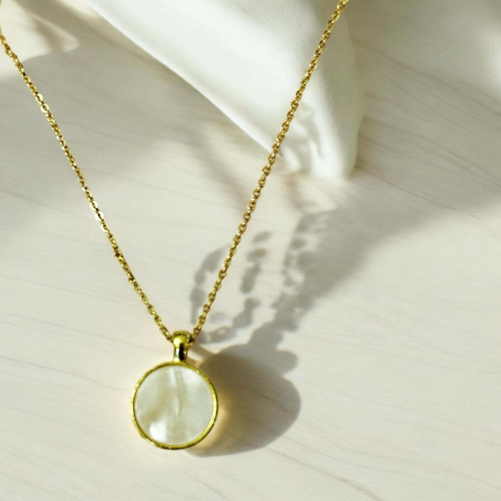 Iridescent shell resin circle pendant showcasing shimmering colors and smooth surface, perfect for jewelry making or accessories.
