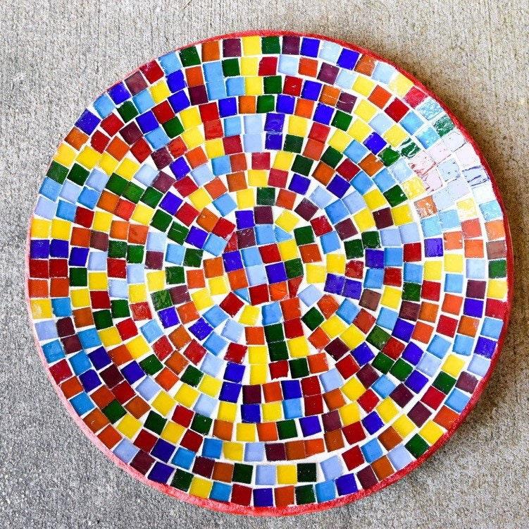Colorful handcrafted rainbow mosaic stepping stone with intricate tile patterns for garden or pathway decoration.