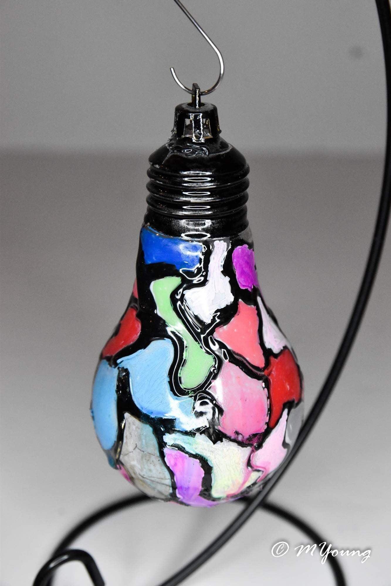 Handmade stained glass mosaic light bulb ornament with colorful holiday design, perfect for festive decoration.