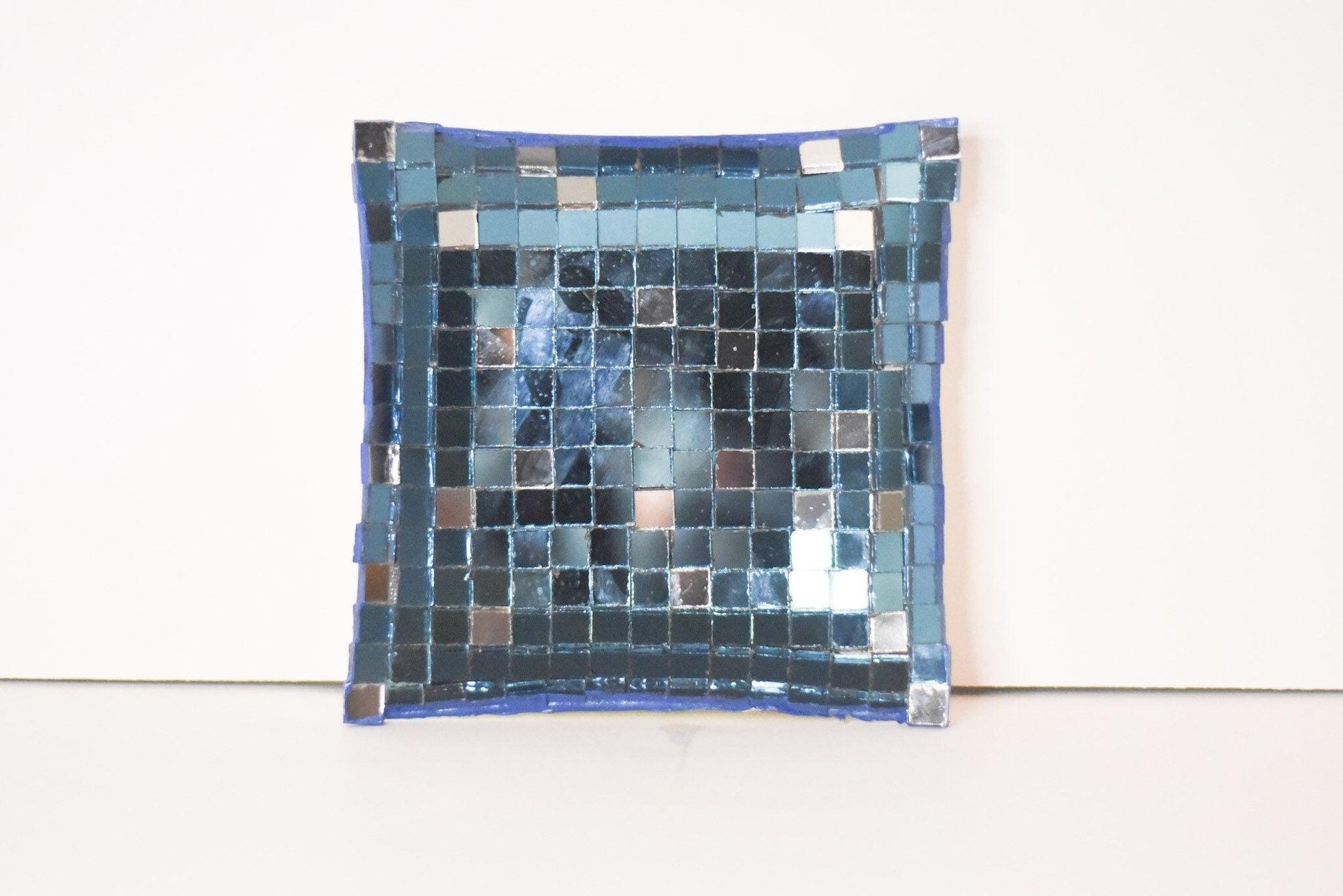 Handcrafted mosaic mirror glass dish with colorful, intricate tile design, ideal for decorative or display purposes.