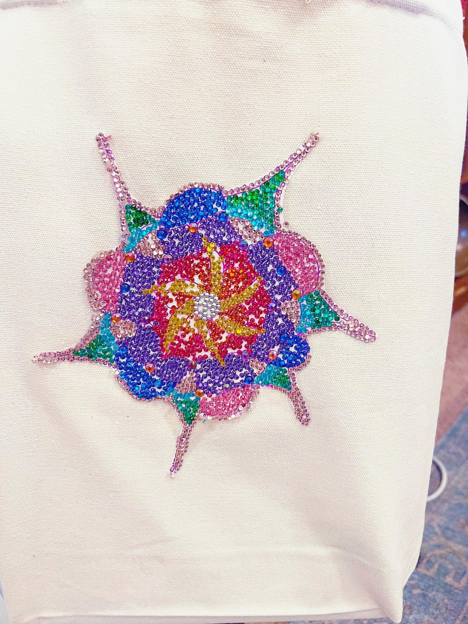 Handmade sparkling starburst diamond art canvas tote bag with colorful starburst design and sturdy handles.
