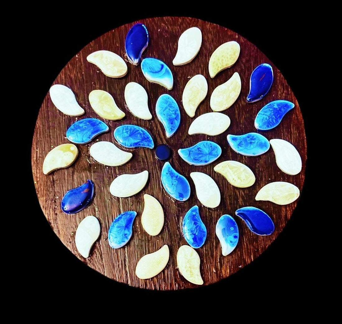 Handcrafted blue and white petal mosaic wooden plant stand with a decorative floral design for indoor or outdoor use.