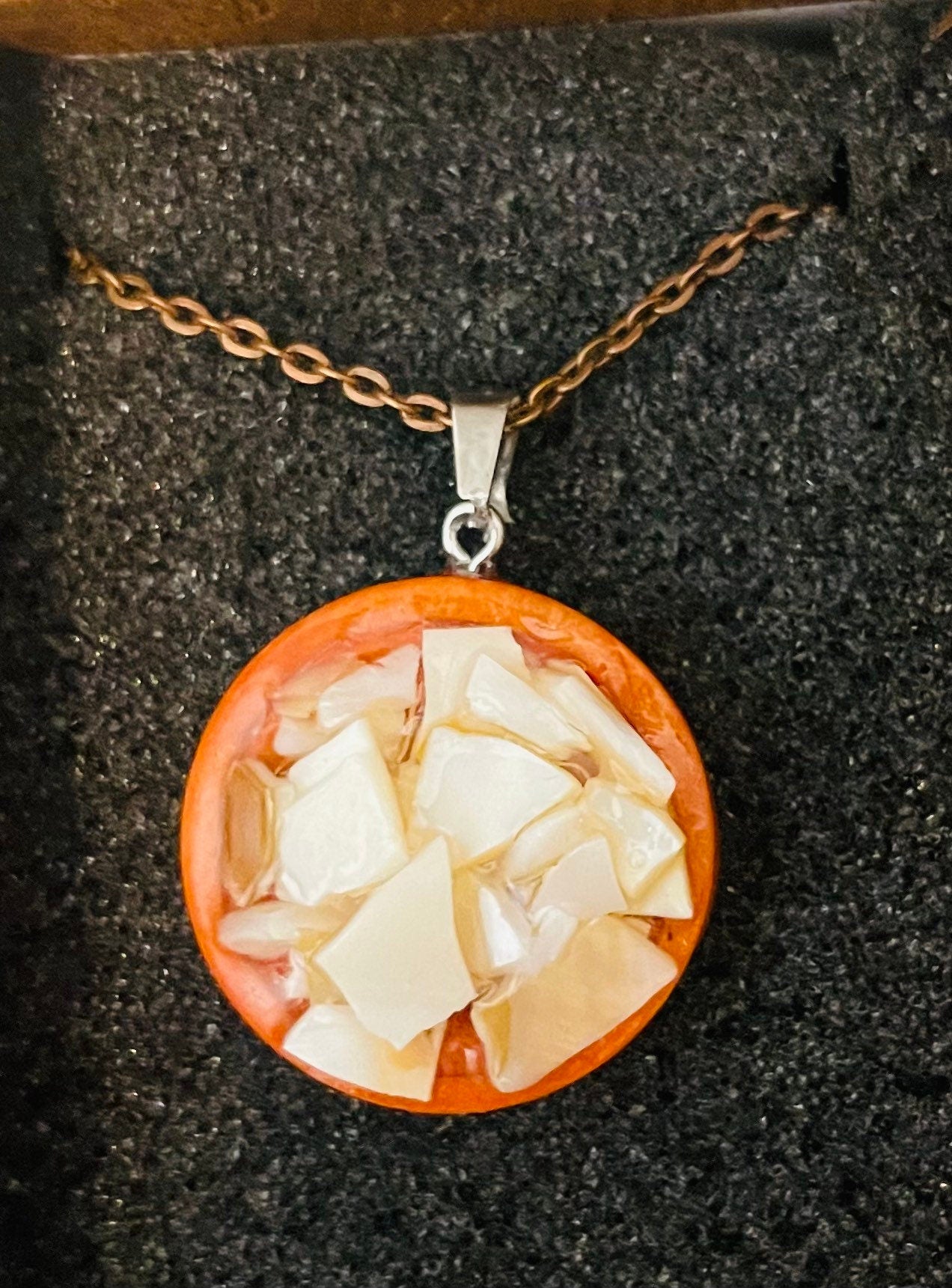 Artisan mosaic shell circle pendant featuring colorful shell pieces in a handcrafted jewelry design.