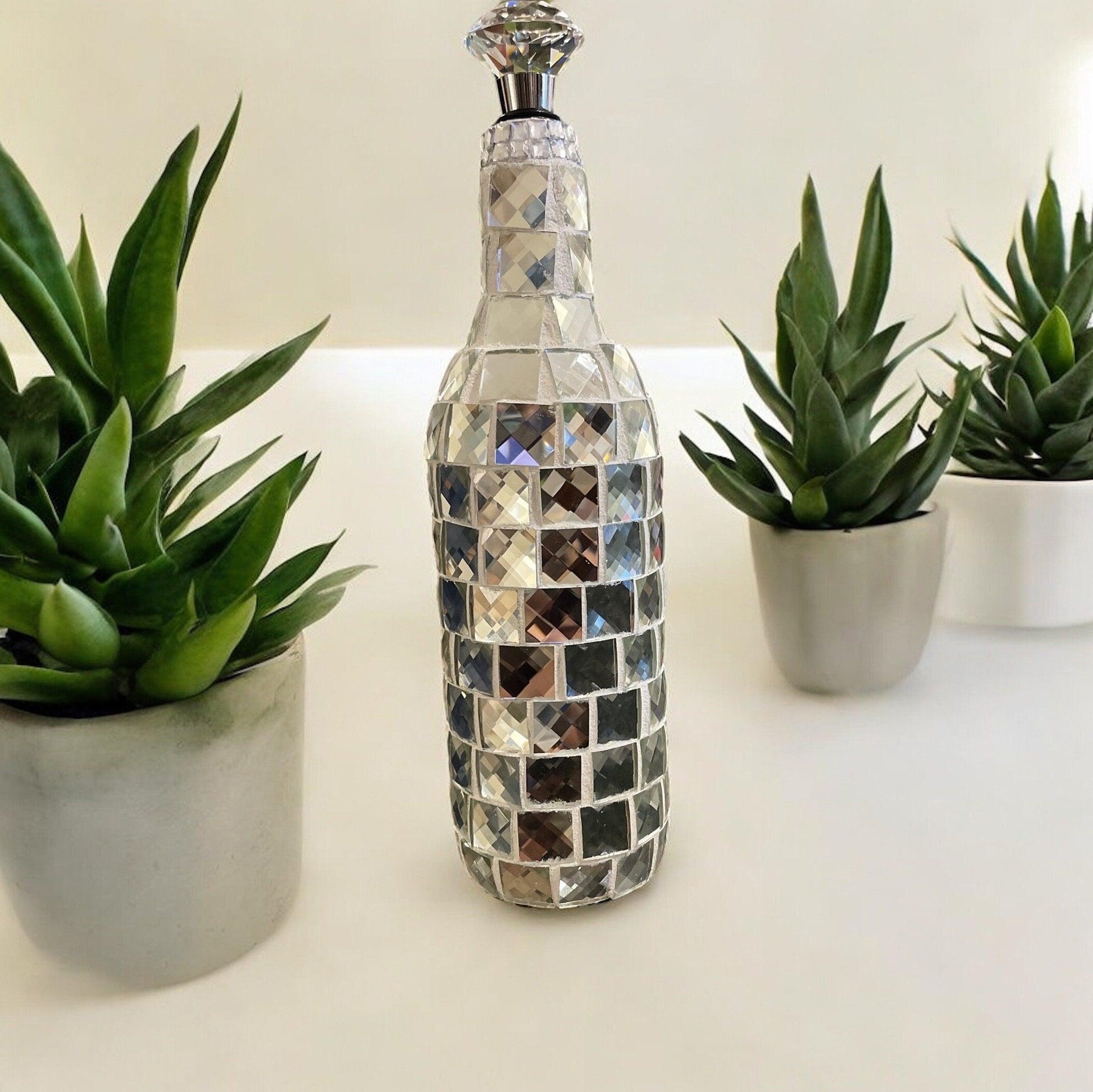 Silver mirrored mosaic wine decanter with elegant design, featuring reflective mosaic pattern and a sleek, modern shape.