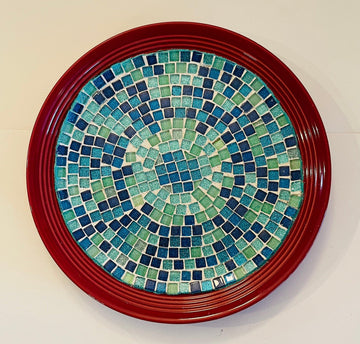 Deep crimson ceramic plate with ocean breeze mosaic pattern, showcasing vibrant blue and turquoise tile designs.