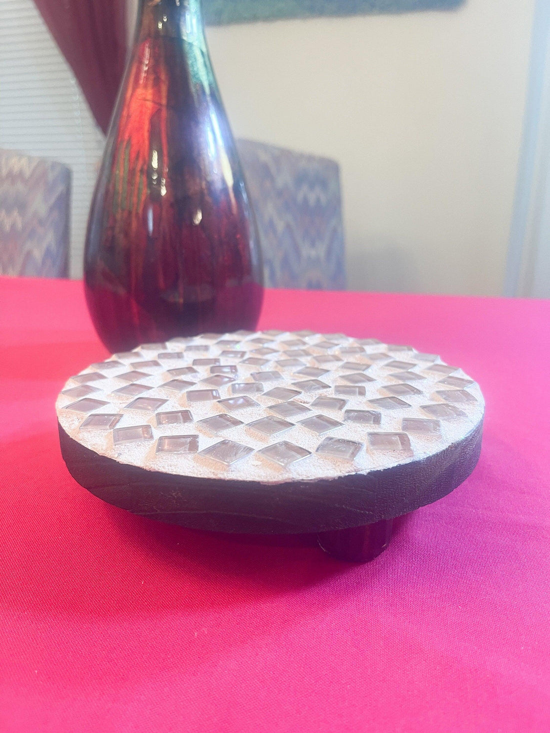 Handcrafted glass mosaic plant stand with colorful tiled surface and sturdy metal frame for indoor or outdoor use.