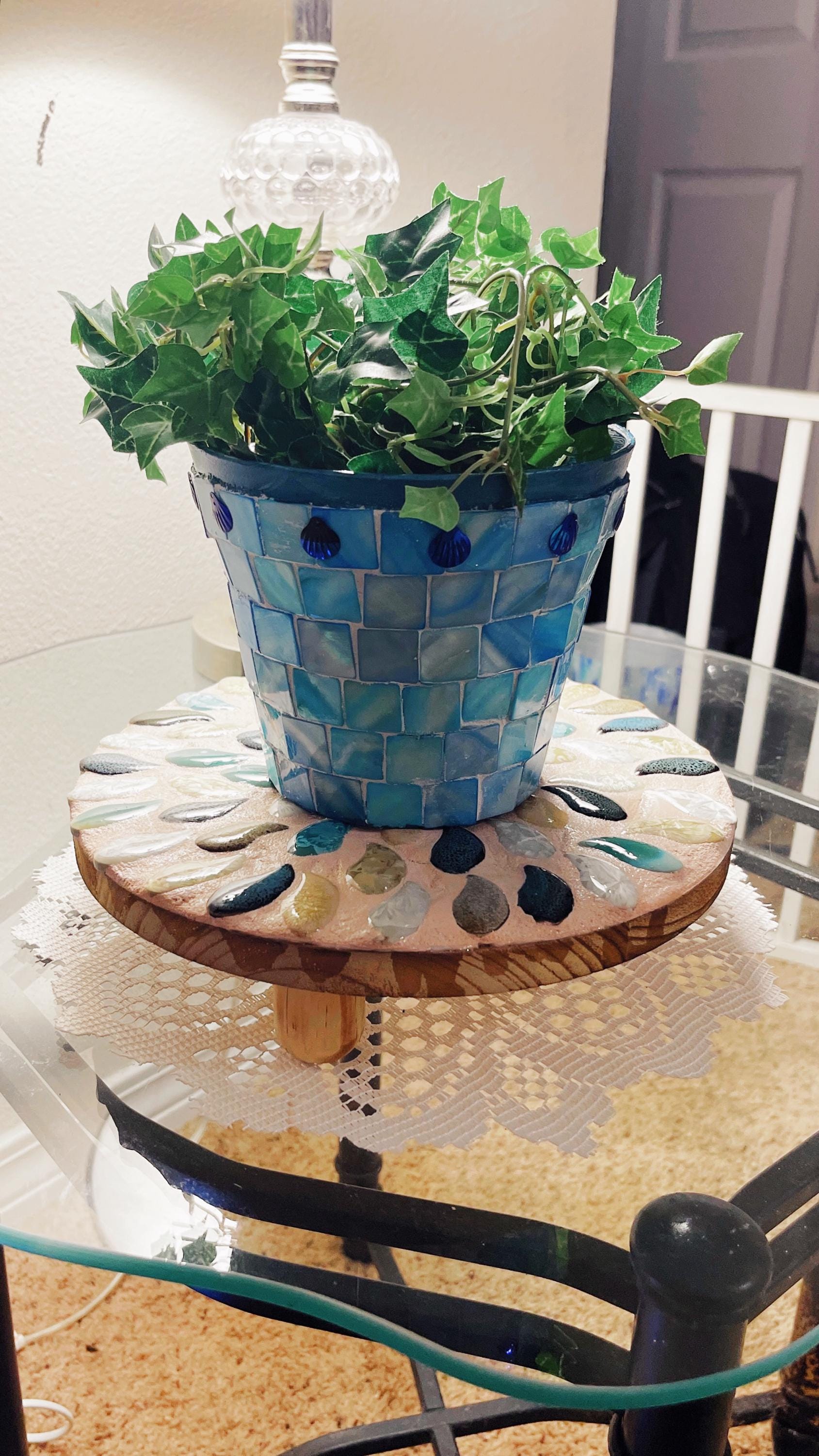 Handcrafted botanical petal mosaic plant stand featuring colorful floral tile design for indoor or outdoor use.
