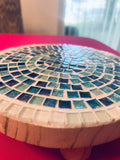 Handcrafted round turquoise glass mosaic plant riser with intricate tile pattern and sturdy base, ideal for elevating potted plants.