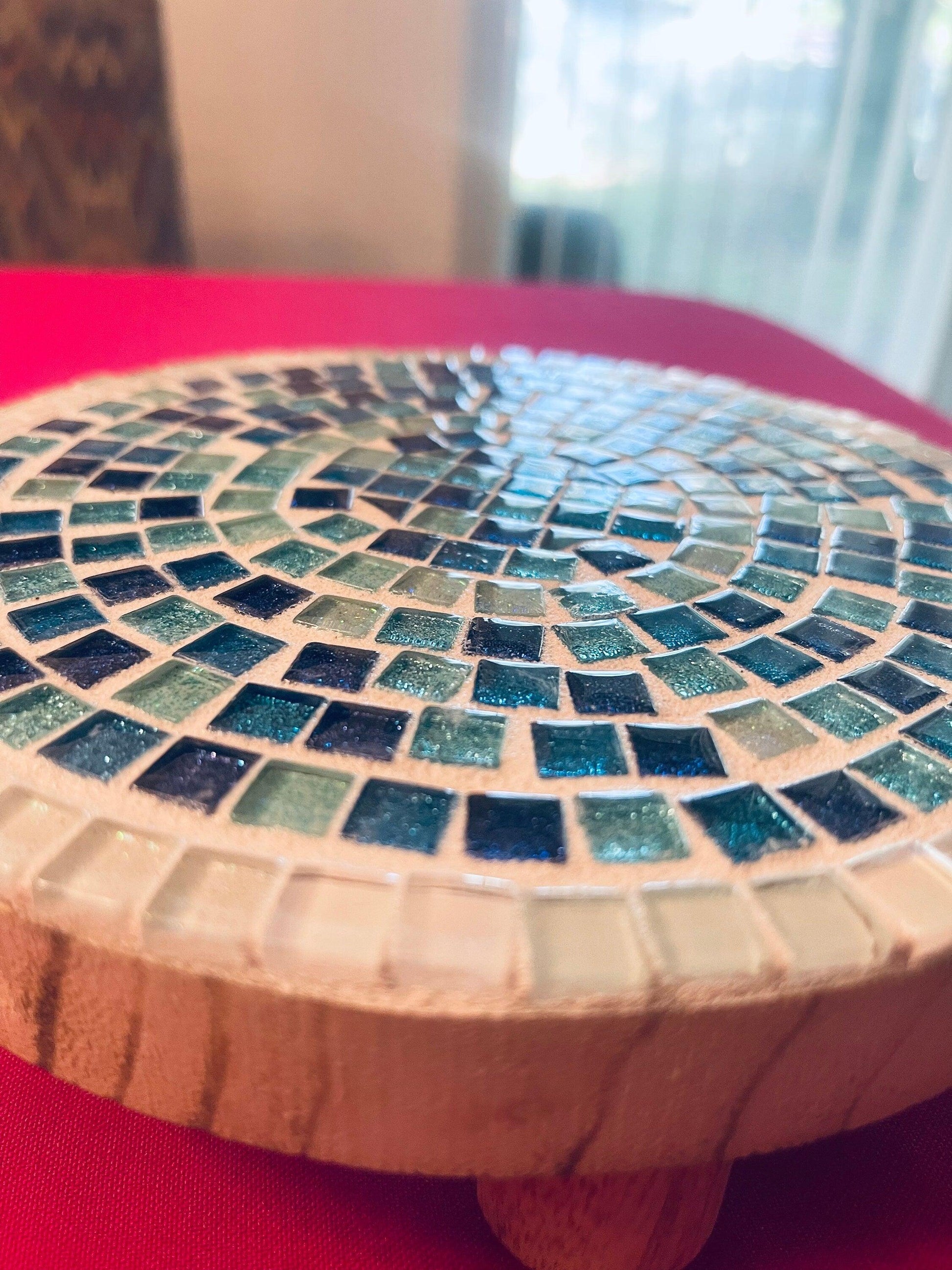 Handcrafted round turquoise glass mosaic plant riser with intricate tile pattern and sturdy base, ideal for elevating potted plants.