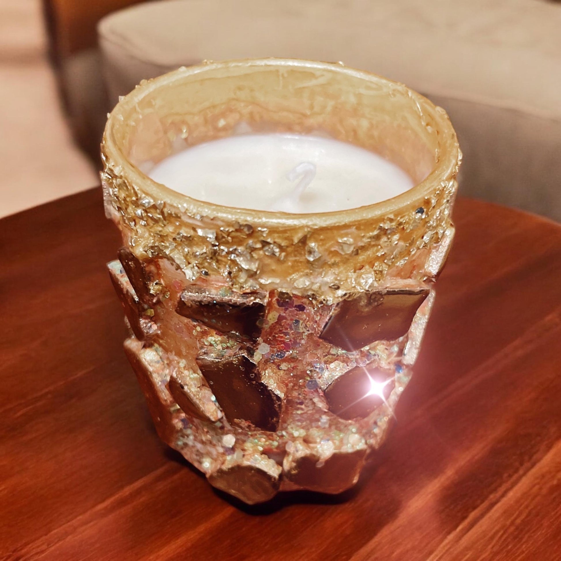 Handmade eucalyptus scented candle in a gold mosaic glass jar, held in hand, showcasing elegant craftsmanship and natural aroma.