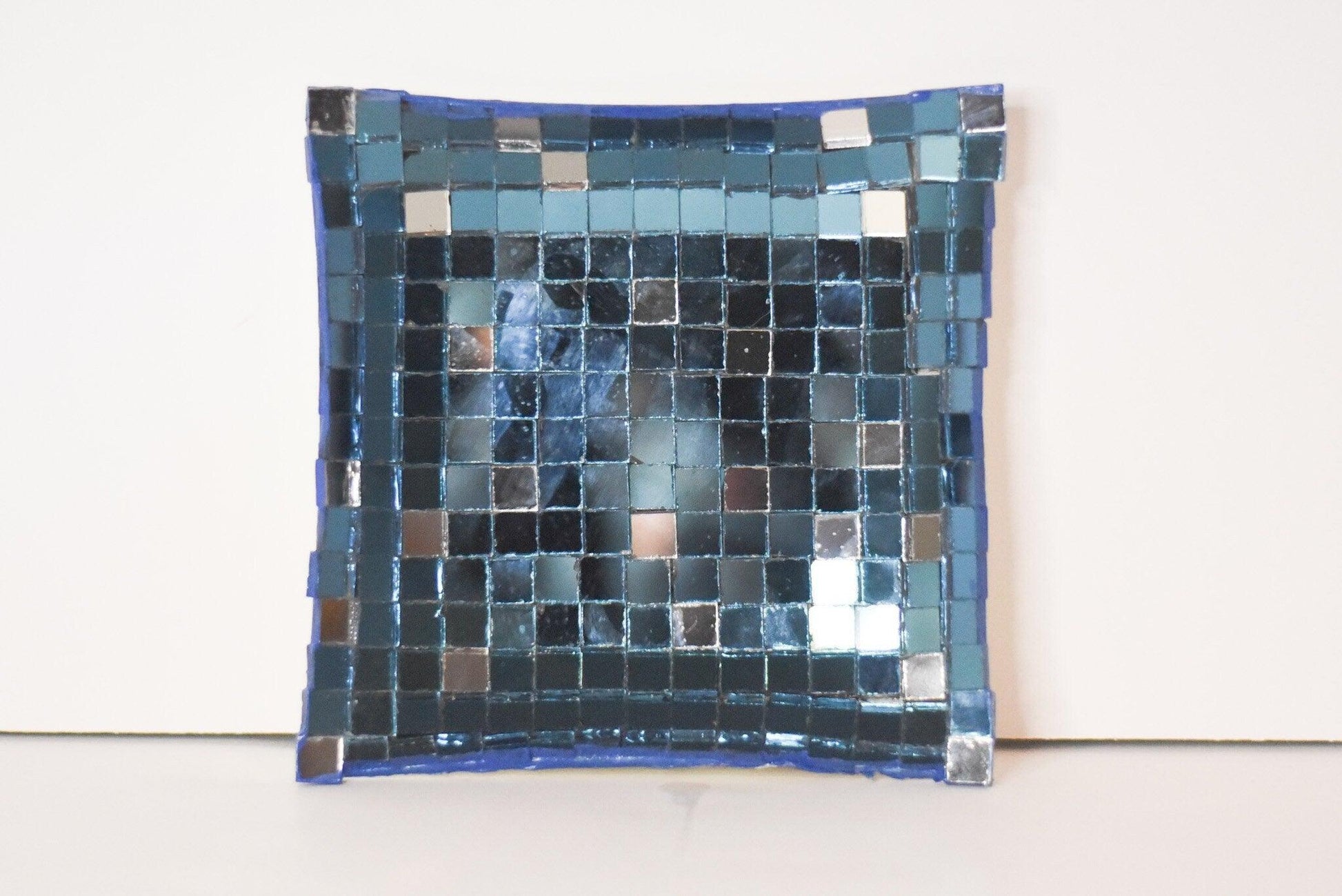 Handcrafted mosaic mirror glass dish with colorful geometric patterns, showcasing intricate tile work and reflective surface.