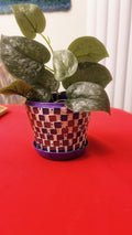 Colorful purple and green mosaic flower pot with floral design, perfect for indoor or outdoor plants.