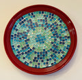Colorful Ocean Breeze mosaic design on a deep crimson ceramic plate, showcasing intricate patterns and vibrant colors.