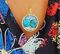 Ocean blue shell medallion necklace with intricate design, featuring a shell pendant on a delicate chain.
