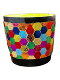 Colorful bouquet of mixed flowers in a rainbow mosaic hexagon planter, showcasing vibrant floral arrangement and decorative planter.