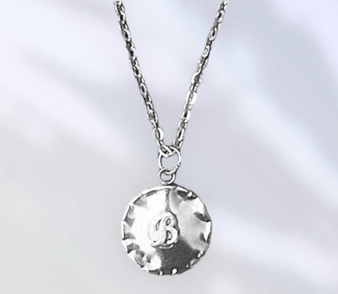 Vintage initial charm necklace featuring a silver chain and personalized letter charm, stylish jewelry accessory.