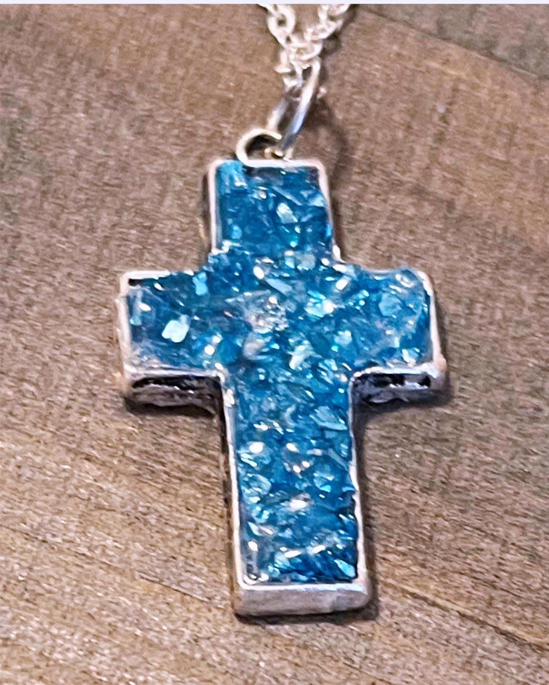 Handcrafted crushed crystal cross necklace with silver chain, featuring sparkling crystal details on a delicate pendant.