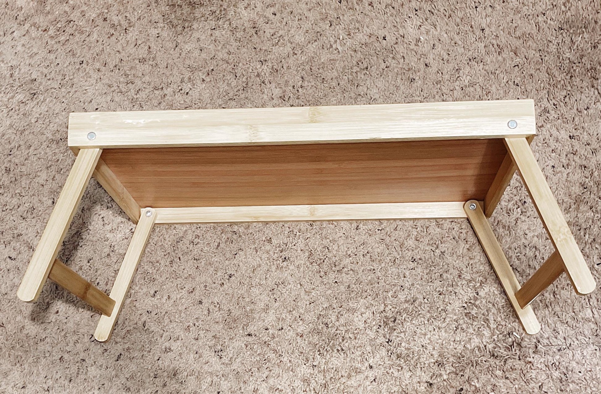 Handcrafted bamboo laptop tray with pink cushion, designed for comfortable desk use and portable workspace setup.