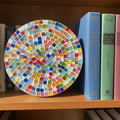 Handcrafted white rainbow mosaic plant stand with colorful tile design for indoor or outdoor use.