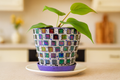 Colorful purple and green mosaic flower pot with floral design, ideal for indoor or outdoor plant display.