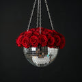Hanging disco ball planter by Miss Bette's Creations with artificial pink carnations and reflective mirrored surface.