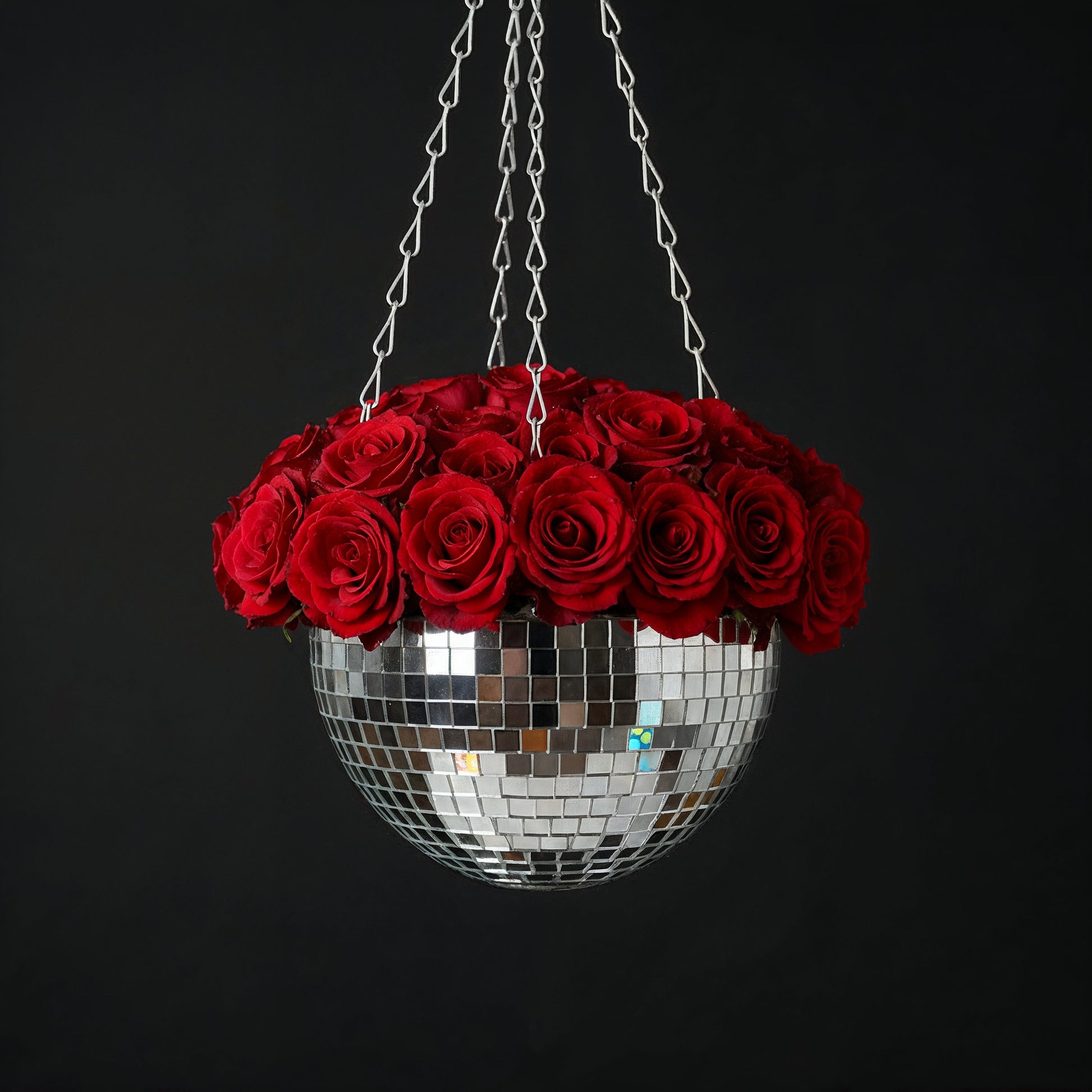 Hanging disco ball planter by Miss Bette's Creations with artificial pink carnations and reflective mirrored surface.