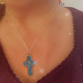 Turquoise glass cross set in silver featuring multiple cross pendants, displayed on a neutral background.