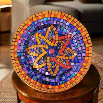 Decorative mid-century modern mosaic plate with colorful geometric patterns on a white background.