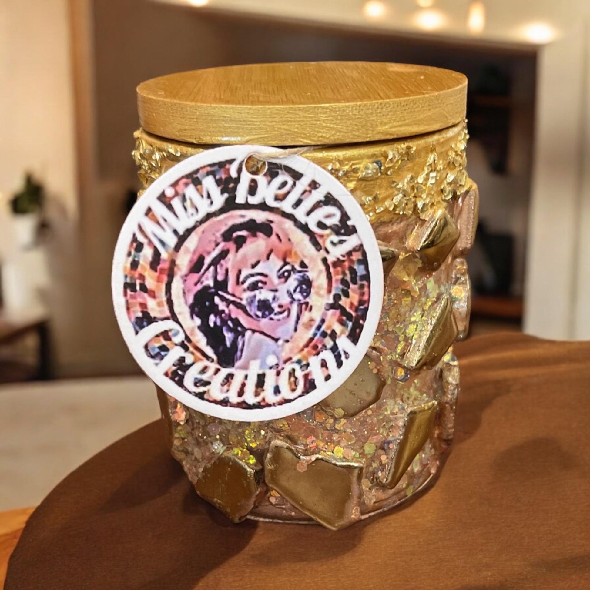 Handmade eucalyptus scented candle in a gold mosaic glass jar, held in hand, showcasing a luxurious and artisanal design.