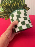Modern green and white checkerboard mosaic herb planter with a round shape and lush herbs inside.