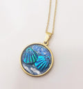 Ocean blue shell medallion necklace featuring a large shell pendant on a delicate chain, stylish and beach-inspired jewelry accessory.