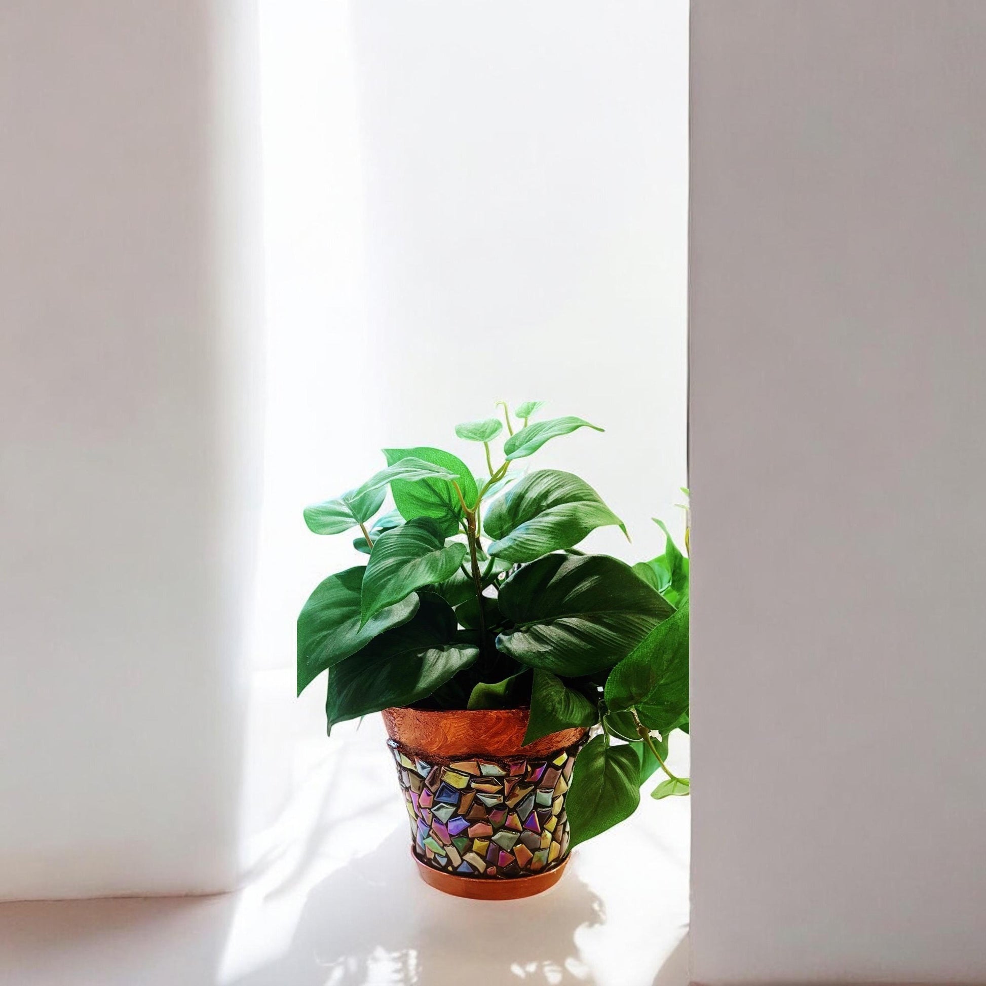 Iridescent mosaic planter with handcrafted design, featuring vibrant, shimmering tiles perfect for indoor or outdoor plants.