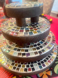 Handcrafted 4-tier mosaic plant stand set with colorful tiled shelves showcasing decorative indoor and outdoor plants.