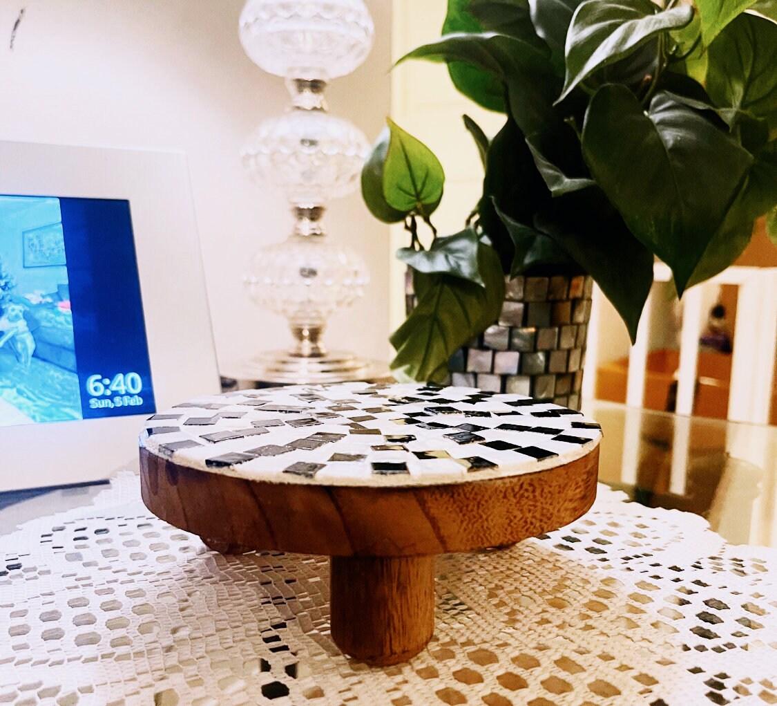 Handmade black and white checkered mosaic plant stand with round top and sturdy base, perfect for indoor or outdoor plants.