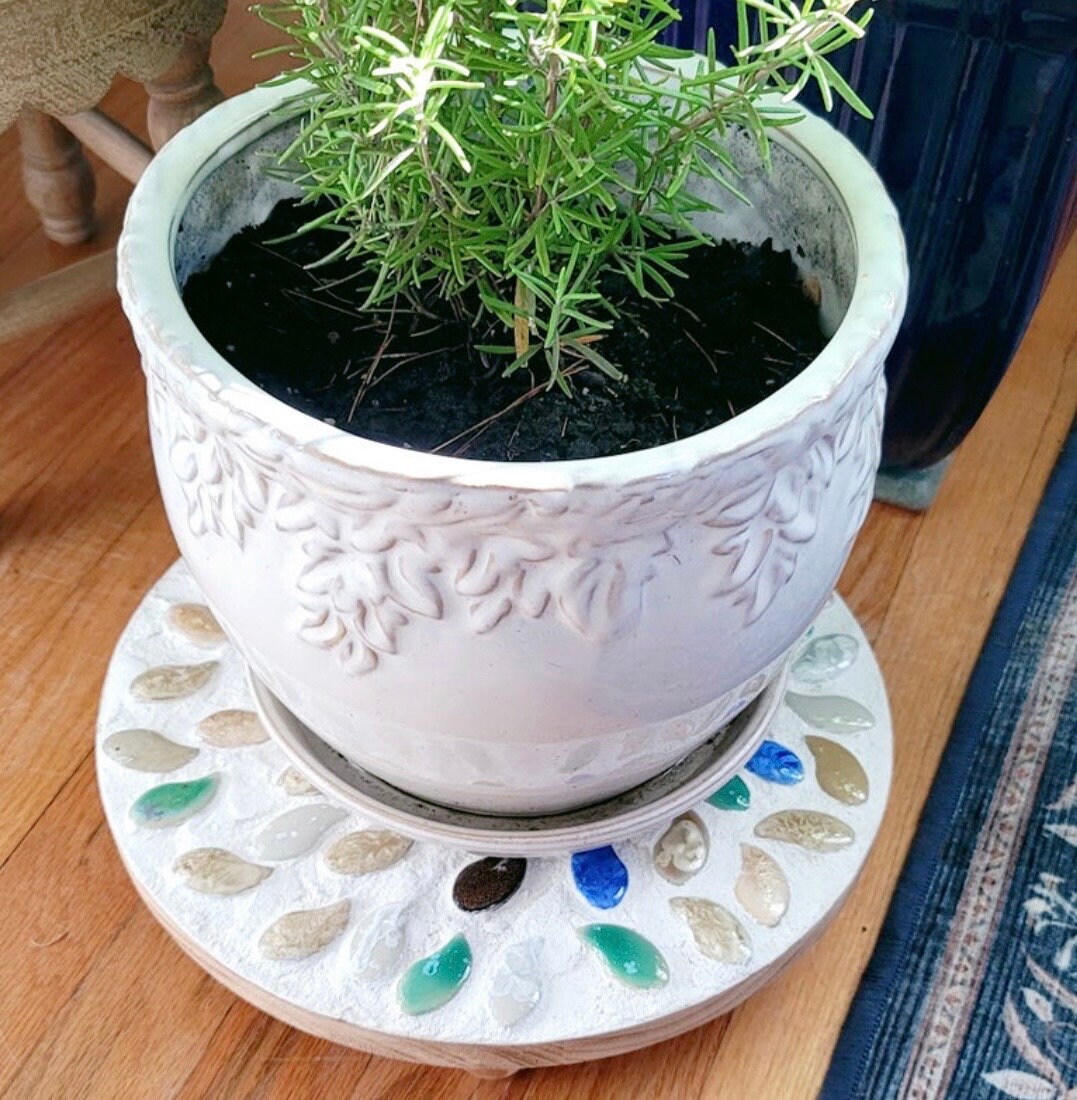 Handcrafted earth tone mosaic plant stand with intricate tile design, suitable for displaying potted plants indoors or outdoors.