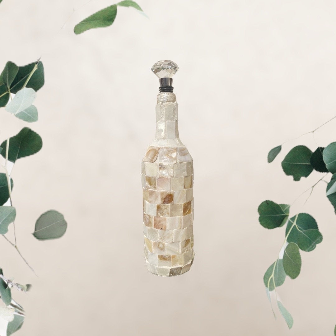 Handcrafted shell glass carafe with decorative bottle stopper, featuring a clear glass body and elegant seaside-inspired design.