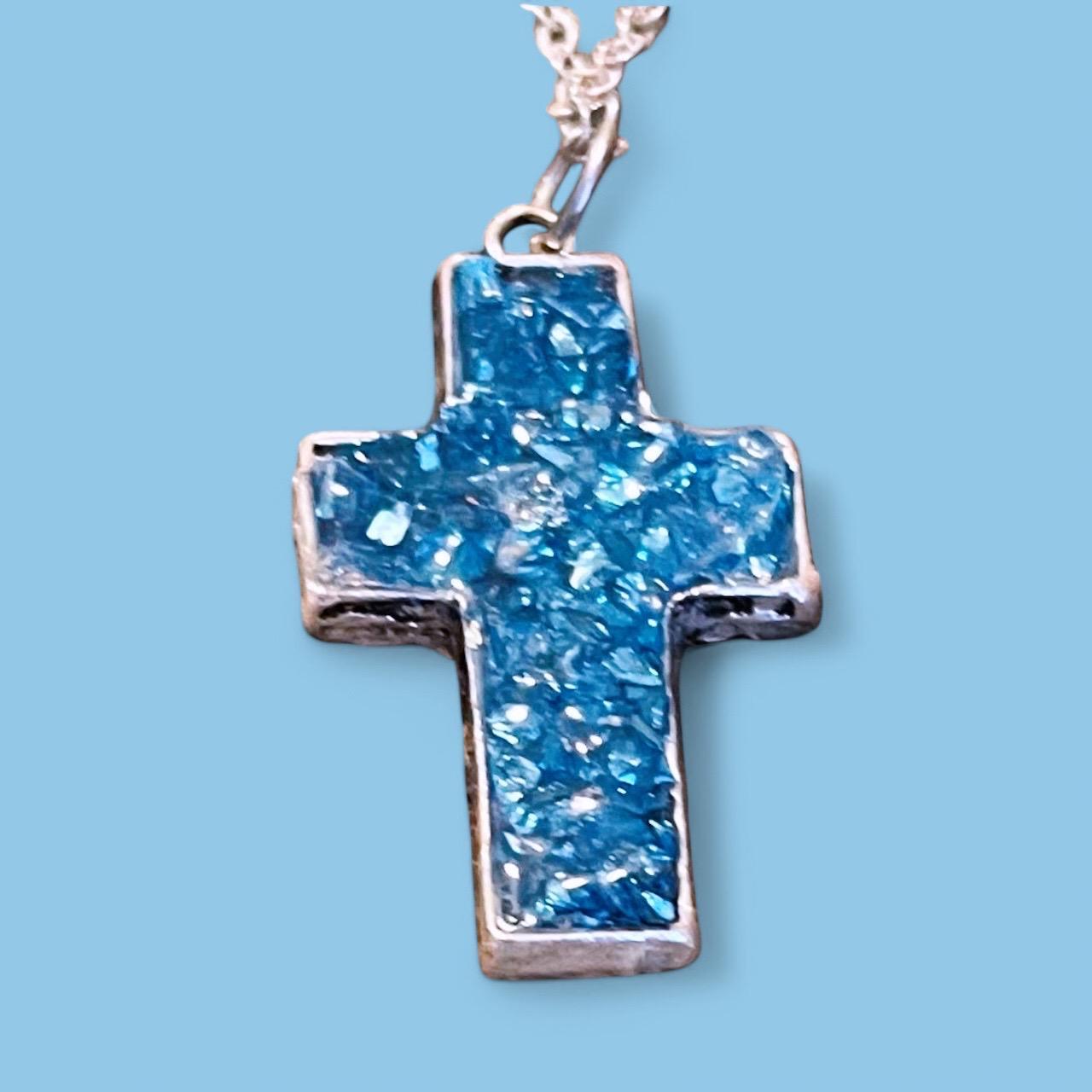 Turquoise glass cross set in silver jewelry featuring detailed cross pendants with turquoise glass accents.