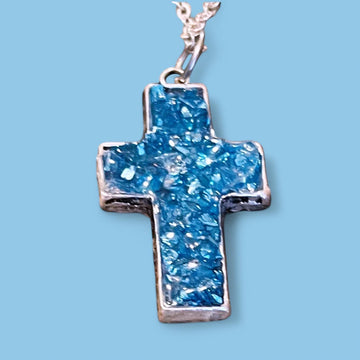 Turquoise glass cross set in silver jewelry featuring detailed cross pendants with turquoise glass accents.