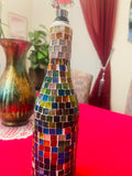 Stained glass look wine decanter with intricate colorful glass design, elegant shape, and glass stopper for pouring and serving wine.