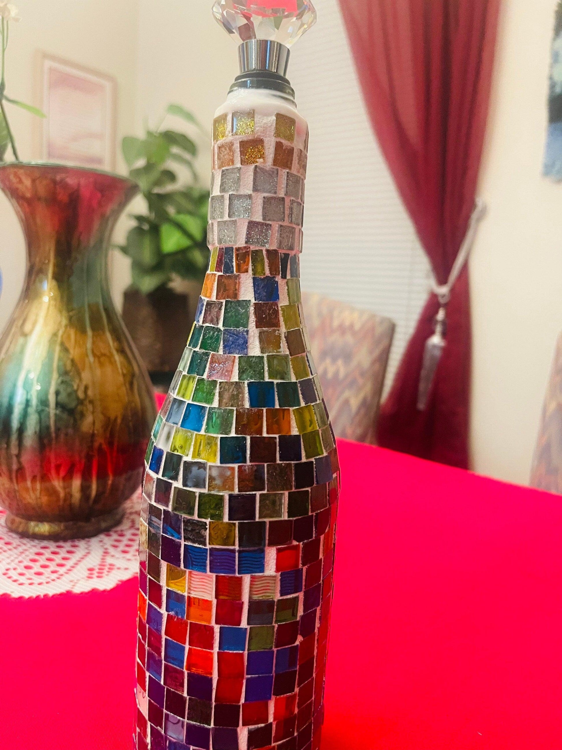 Stained glass look wine decanter with intricate colorful glass design, elegant shape, and glass stopper for pouring and serving wine.