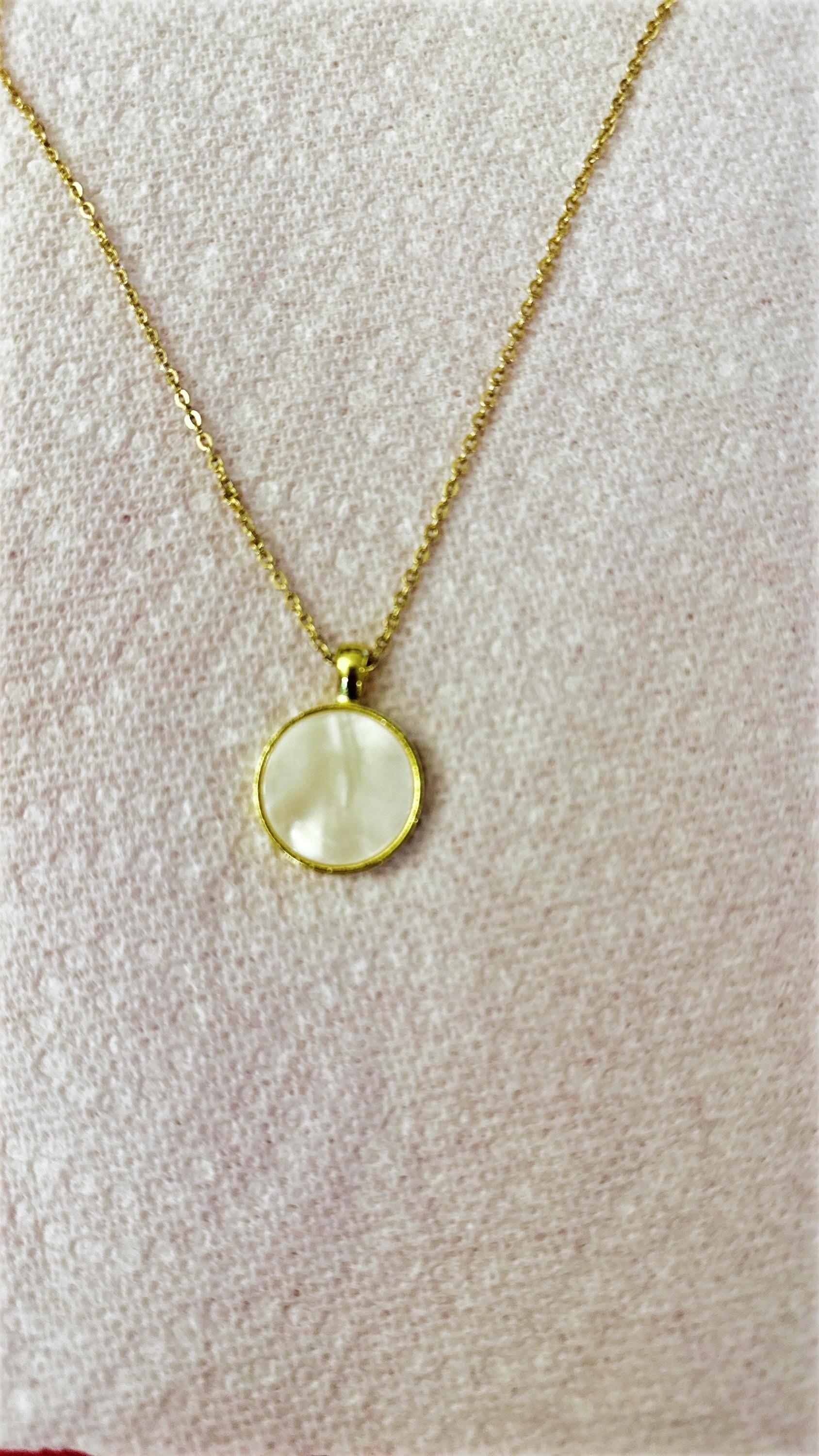 Iridescent shell resin circle pendant showing a shiny, colorful, round jewelry piece with a smooth surface and natural shell pattern.
