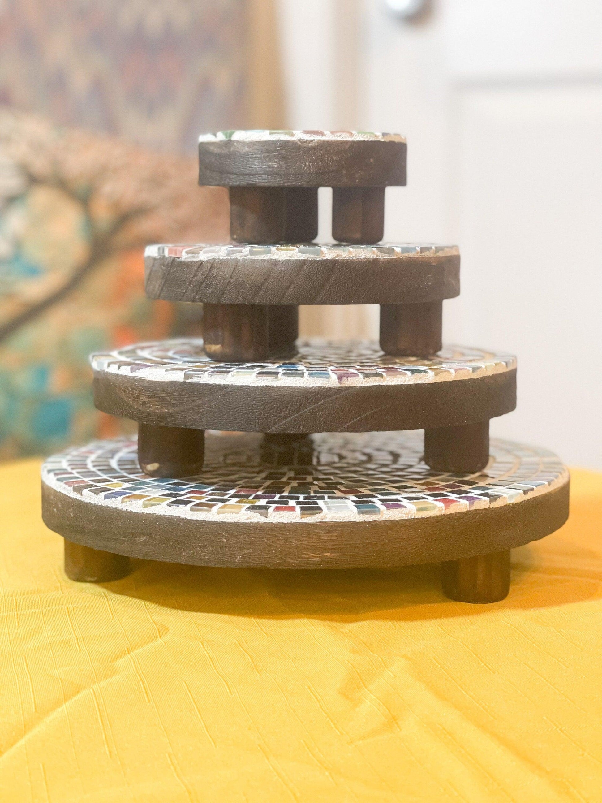Handcrafted 4-tier mosaic plant stand set with colorful tile designs, perfect for displaying potted plants indoors or outdoors.